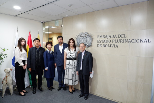 볼리비아 오시오 부스티요스 대리 대사와 부인(각각 왼쪽에서 네 번째, 다섯 번째)이 (왼쪽부터) 오테로 양(대리 대사와 부인의 딸), 이갑수 코리아포스트 편집국장, 조경희 코리아포스트 부회장과 포즈를 취하고 있다. 맨 오른쪽은 코리아포스트 발행인 겸 회장이다