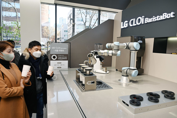 LGE 서초본점 LG 클로이 바리스타봇: LG베스트샵 서초본점을 방문한 고객들이  LG 클로이 바리스타봇이 핸드드립 방식으로 만든 커피를 즐기고 있다.