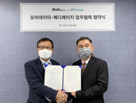 왼쪽부터 메디에이지 김강형 대표와 오른쪽 모아데이타 한상진 대표가 업무 협약을 체결한 뒤 기념 촬영을 하고 있다/사진=모아데이타.