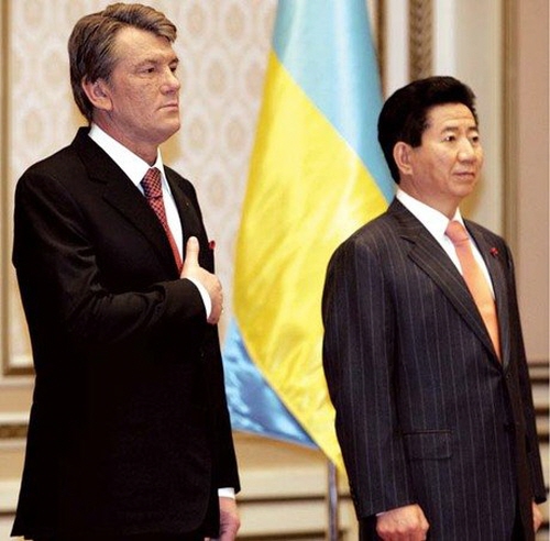 빅토르 유셴코 전 우크라이나 대통령(왼쪽)과 당시 한국의 노무현 대통령이 국기에 대한 경례를 2006년 12월 서울에서 하고 있다. 문재인 대통령(당시 비서실장)은 노 전 대통령을 진심으로 존경하는 것으로 알려져 있다.