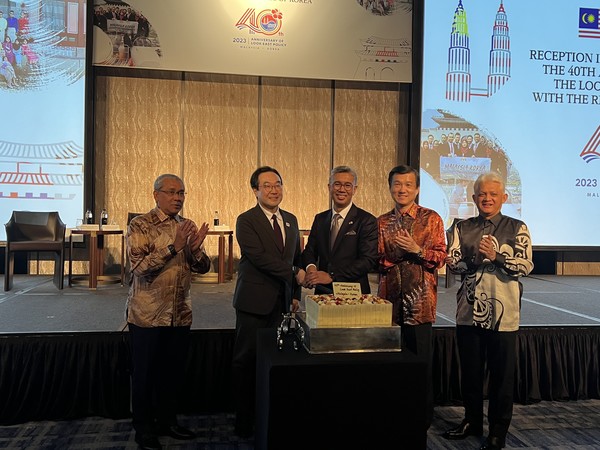 말레이시아의 자프룰 아지즈 국제통상산업부 장관과 한국 외교부의 이도훈 제2차관(왼쪽에서 각각 세 번째와 두 번째)이 주한 말레이시아 다툭 림 쥐아이 진  대사 (왼쪽에서 2번째)와 함께 룩 이스트 정책 40주년 기념 케이크를 자르고 있다.