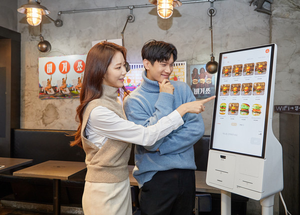 삼성전자 모델이 서울 성동구에 위치한 햄버거 전문점 '버거쇼'에 설치된 신제품 '삼성 키오스크'를 소개하고 있다.